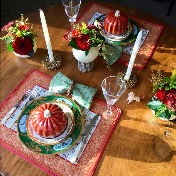 Tabletop with Aubrac orange-bordered placemats, green chargers, pumpkin soup tureens and green Small Bee napkins.