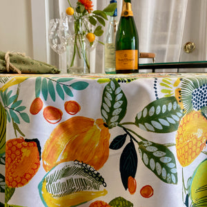 Agrume Fruit tablecloth. White background with yellow, orange and green citrus fruits, kiwis and berries.